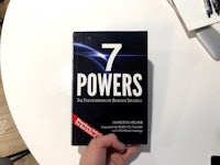 a person holding up a book called 7 powers
